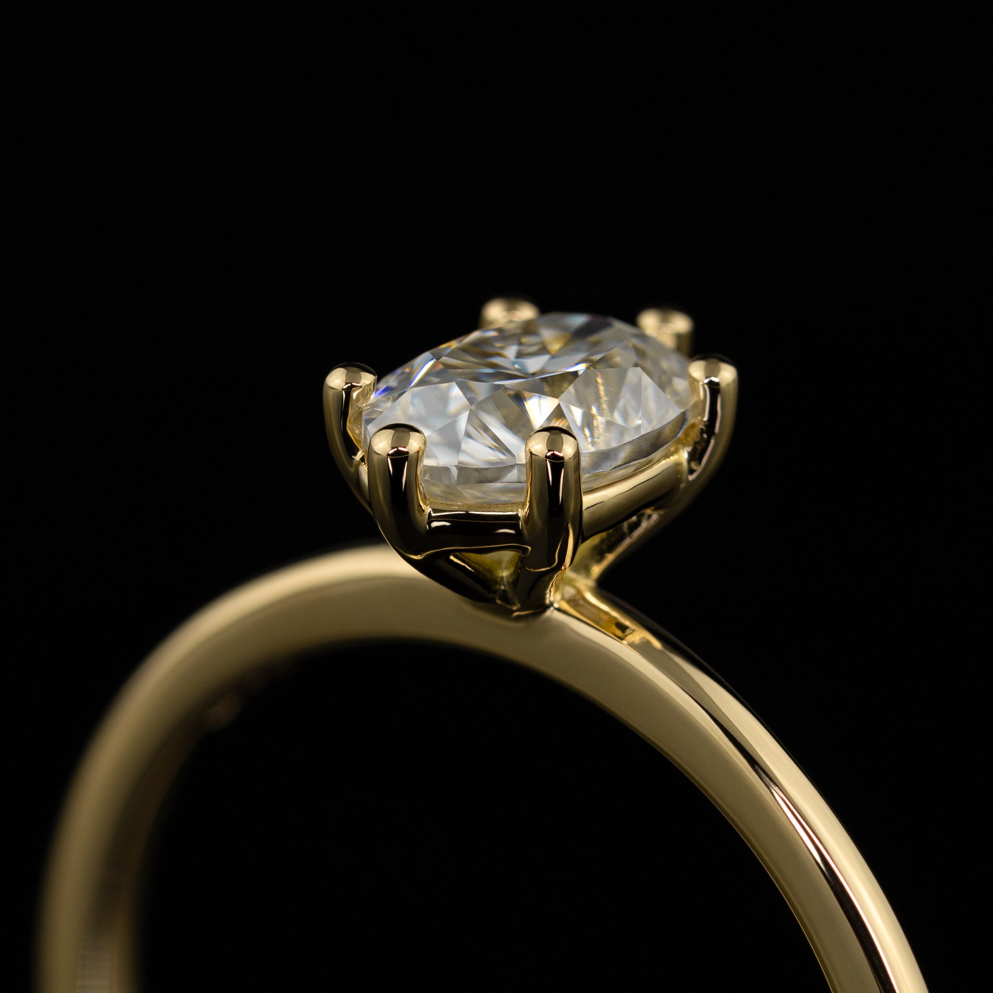 Seitenansicht der offen gestalteten Mittelsteinfassung. Schlichter Verlobungsring mit ovalem Mittelstein, keine Seitensteine, moderner Solitär aus Gelbgold mit Vintage-Vibe, individuell handgefertigt vom Goldschmiedemeister in der Goldschmiede Goldzeit in Nürnberg