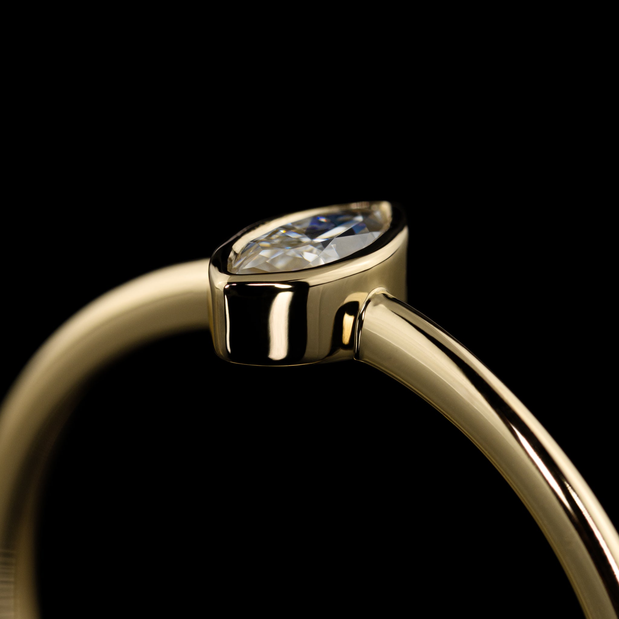 zarter Verlobungsring mit navetteförmigem Diamant in Zargenfassung, Gelbgold poliert, handgearbeitet vom Goldschmied, Nahaufnahme Zargenfassung seitlich